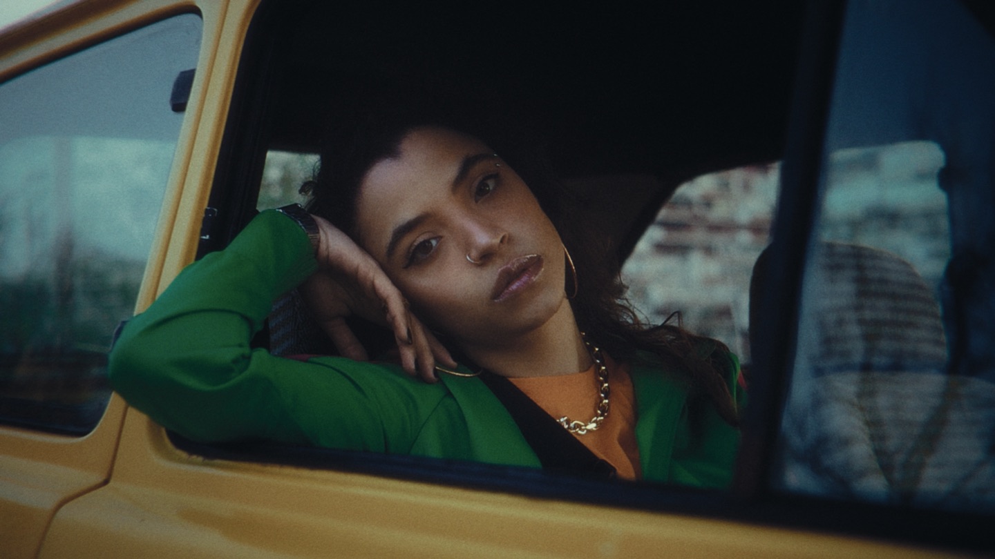 Portrait of a woman leaning out of a yellow car